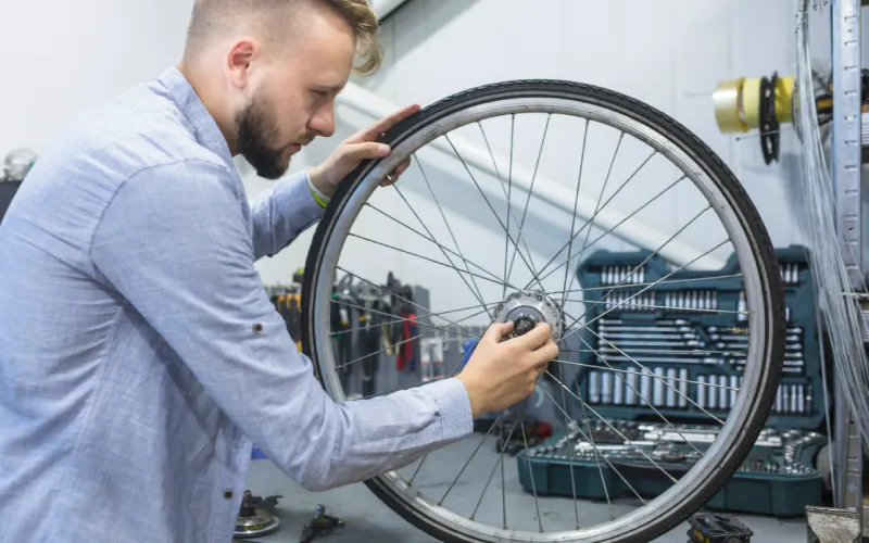 man-repairing-wheel-bicycle-workshop